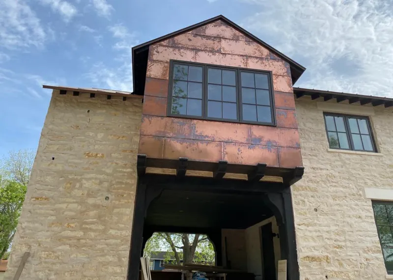 Copper metal panel facade on a stone building for Skylight Installation in Vernon